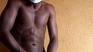 Африканский мускулистый мужчина наслаждается сольной игрой со своим большим членом