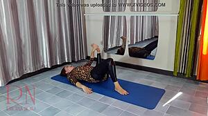 Un model de gimnastică în colanți și pantaloni de yoga își arată flexibilitatea